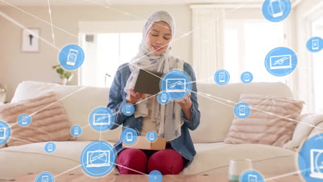 Animation-Eines-Globus-Mit-Einem-Netzwerk-Von-Verbindungen-über-Einer-Gemischtrassigen-Frau-Im-Hijab,-Die-Ein-Tablet-Verwendet