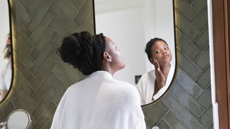 Young-African-American-woman-examines-her-skin-in-a-mirror-at-home