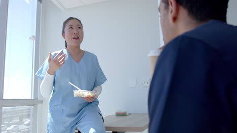 Young-Asian-healthcare-worker-chats-with-a-colleague-during-a-break-in-the-hospital