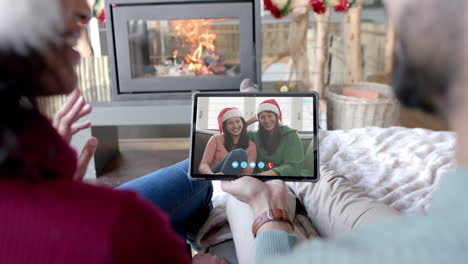Happy-diverse-couple,-mother-and-daughter-having-christmas-tablet-video-call,-slow-motion