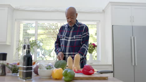 Hombre-Afroamericano-Mayor-Cocinando,-Cortando-Verduras-En-La-Cocina,-Cámara-Lenta