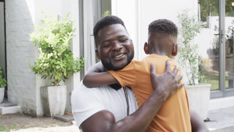 African-American-father-hugs-son-outdoors
