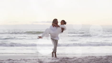 Animation-of-light-spots-over-happy-african-american-groom-carrying-bride-on-beach-at-wedding