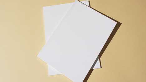 Video-of-books-with-blank-white-pages-and-copy-space-on-yellow-background