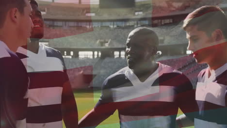 Animation-Der-Schweizer-Flagge-über-Verschiedenen-Männlichen-Rugbyspielern,-Die-Sich-Im-Stadion-Unterhalten