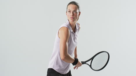 Young-Caucasian-woman-plays-tennis-indoors-on-a-white-background
