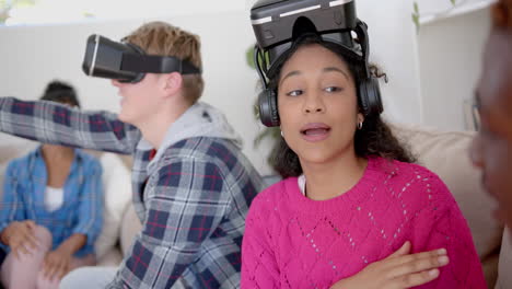 Happy-diverse-group-of-teenage-friends-talking-and-using-vr-headsets-at-home,-slow-motion