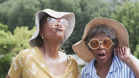 Porträt-Glücklicher-älterer-Afroamerikanischer-Freundinnen,-Die-Im-Garten-Lustige-Gesichter-Machen,-Zeitlupe