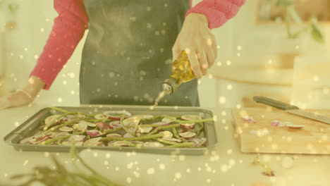 Mujer-Birracial-Vertiendo-Aceite-De-Oliva-Sobre-Verduras-Picadas-En-La-Cocina,-Cocinando-Sobre-Manchas-De-Luz