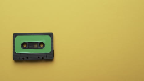 Video-of-retro-tape-with-green-label-with-copy-space-on-yellow-background