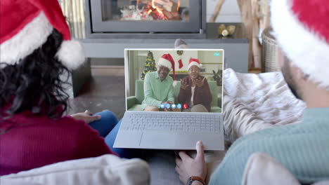 Glückliches,-Vielfältiges-Paar-Und-ältere-Eltern-Mit-Weihnachtlichem-Laptop-Videoanruf,-Zeitlupe