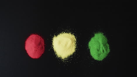 Video-Von-Roten,-Gelben-Und-Grünen-Pulvern-Mit-Kopierraum-Auf-Schwarzem-Hintergrund