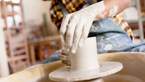 African-american-male-potter-using-potter's-wheel-in-pottery-studio,-slow-motion