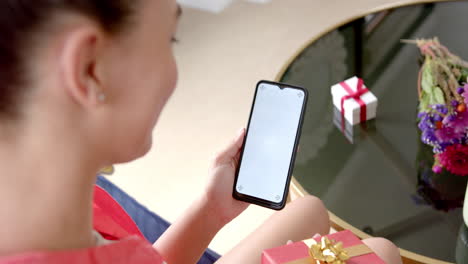Biracial-Teenager-Mädchen-Mit-Geschenk,-Das-Einen-Smartphone-Videoanruf-Mit-Kopierraum-Bildschirm-Und-Zeitlupe-Durchführt