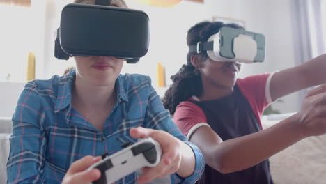 Happy-diverse-teenage-female-friends-playing-video-games-with-vr-headsets-at-home,-slow-motion