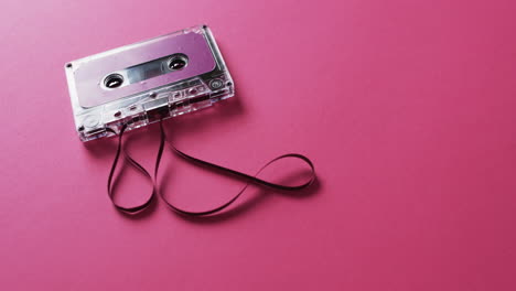 Video-of-retro-tape-with-pink-label-and-pulled-out-tape-with-copy-space-on-pink-background