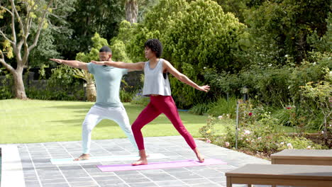 Fokussiertes-Afroamerikanisches-Paar,-Das-Yoga-Im-Garten-Praktiziert,-Kopierraum,-Zeitlupe