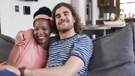 Diverse-couple-enjoys-a-cozy-moment-on-a-couch-at-home