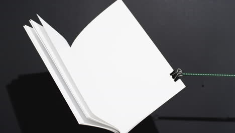 Video-of-book-with-string-and-white-blank-pages-and-copy-space-on-black-background