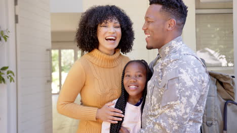 Portrait-of-happy-african-american-male-soldier-embracing-his-daughter-at-home,-slow-motion