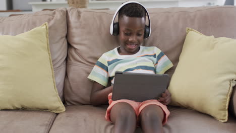 African-American-boy-enjoys-digital-content-at-home-using-a-tablet