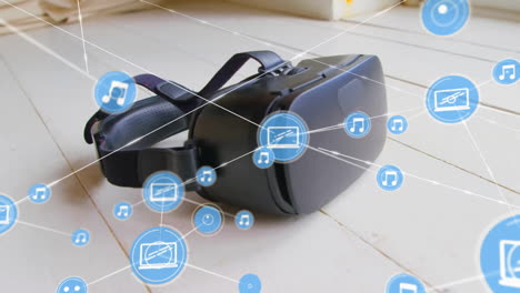 Animation-of-network-of-connections-with-icons-over-vr-headset-on-floor