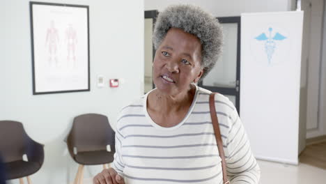 Afroamerikanische-Seniorin-Spricht-An-Der-Rezeption-Des-Krankenhauses,-Zeitlupe