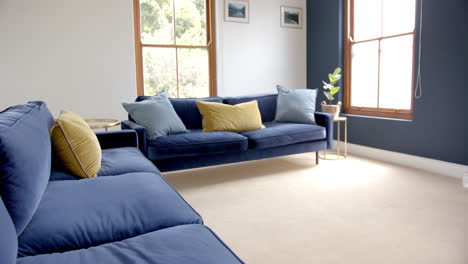 Cushions-on-two-blue-sofas-in-sunny-living-room,-copy-space,-slow-motion