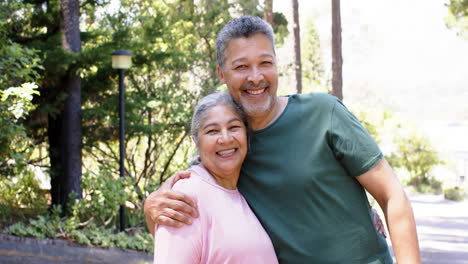 Happy-biracial-senior-couple-embracing-in-sunny-garden