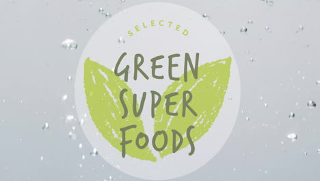 Animation-of-green-super-foods-text-on-circle-on-fruit-falling-into-water-background
