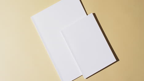 Video-of-books-with-blank-white-pages-and-copy-space-on-yellow-background