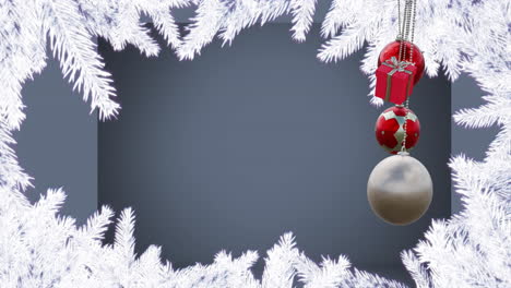 Animation-Von-Hängenden-Kugeln,-Geschenkbox-Mit-Schneebedeckten-Tannenblättern-Vor-Grauem-Hintergrund