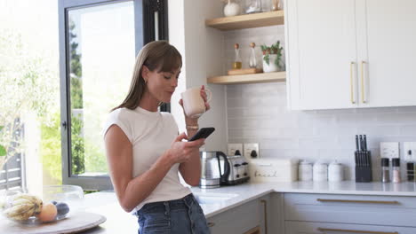Middle-aged-Caucasian-woman-enjoys-a-coffee-break-at-home,-with-copy-space