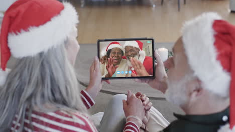Happy-diverse-senior-couples-having-christmas-tablet-video-call,-slow-motion