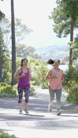 Happy-asian-female-friends-running-near-forest-on-on-sunny-day,-slow-motion