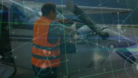 Animation-of-connected-dots-over-caucasian-aircraft-mechanic-checking-airplane-at-airport
