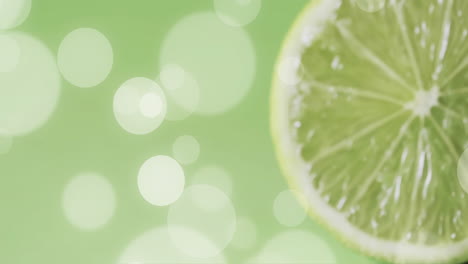 Komposition-Aus-Halbierter-Limette-Und-Weißen-Flecken-Auf-Grünem-Hintergrund