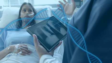 Animation-of-dna-strands-over-diverse-female-doctor-with-tablet-and-patient-in-hospital