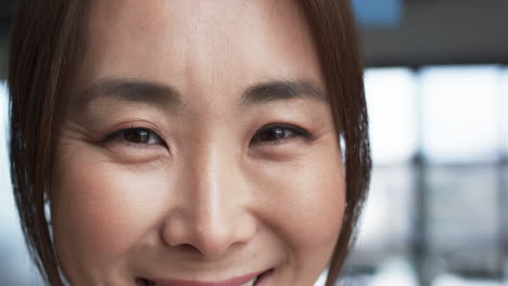 Close-up-of-smiling-Asian-businesswoman-with-subtle-makeup-and-dark-hair