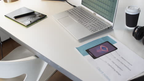 Laptop,-Smartphone-Und-Druckmaterialien-Liegen-Auf-Einem-Schreibtisch-In-Einer-Geschäftsumgebung