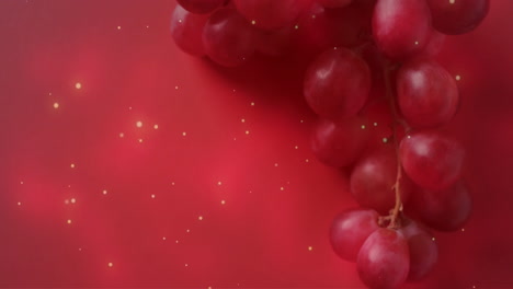 Composition-of-spots-of-light-over-red-grapes-on-pink-background