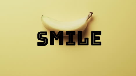 Animation-of-smile-text-over-banana-on-yellow-background