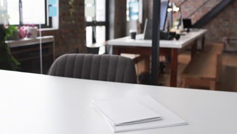 Ein-Weißer-Schreibtisch-Mit-Einem-Geschlossenen-Laptop-Und-Papieren-In-Einem-Modernen-Geschäftsbüro-Mit-Platz-Zum-Kopieren