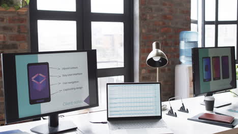 Modern-office-desk-in-a-business-setting-is-equipped-with-a-laptop,-monitor,-and-presentation-screen