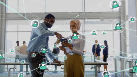 Animation-of-network-of-connections-with-icons-over-diverse-business-people-in-office