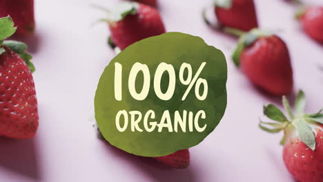 Animation-of-100-percent-organic-text-over-strawberries-on-pink-background