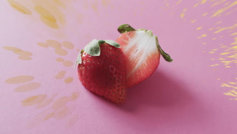 Komposition-Aus-Halbierten-Erdbeeren-Und-Lichtflecken-Auf-Rosa-Hintergrund