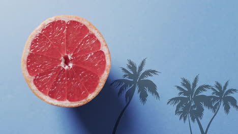 Komposition-Aus-Halbierten-Grapefruits-Und-Palmen-Auf-Blauem-Hintergrund