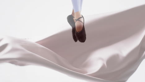 Animation-of-caucasian-female-ballerina-over-floating-cloth-on-white-background