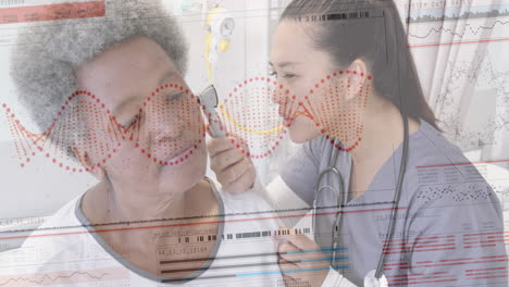 Animation-of-dna-on-interface-over-diverse-female-doctor-checking-ear-of-senior-female-patient